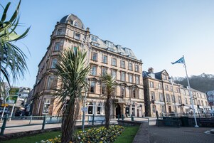 Un edificio histórico con arquitectura clásica, que destaca por una torre en esquina y múltiples ventanas.