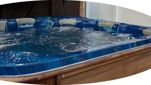A hot tub with a wooden frame and a blue interior. - Loredo Motel (Kaitaia)