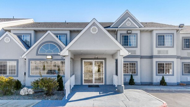 A multi-story building with a symmetrical facade, large windows, and a central entrance with a covered porch. - Quality Inn & Suites Elko (Elko)