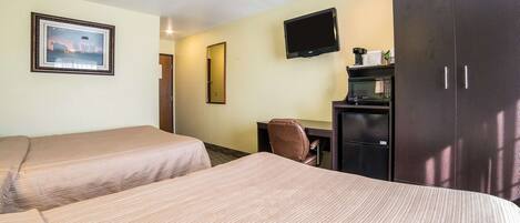 A hotel room with two beds, a desk, a television, and a wardrobe.