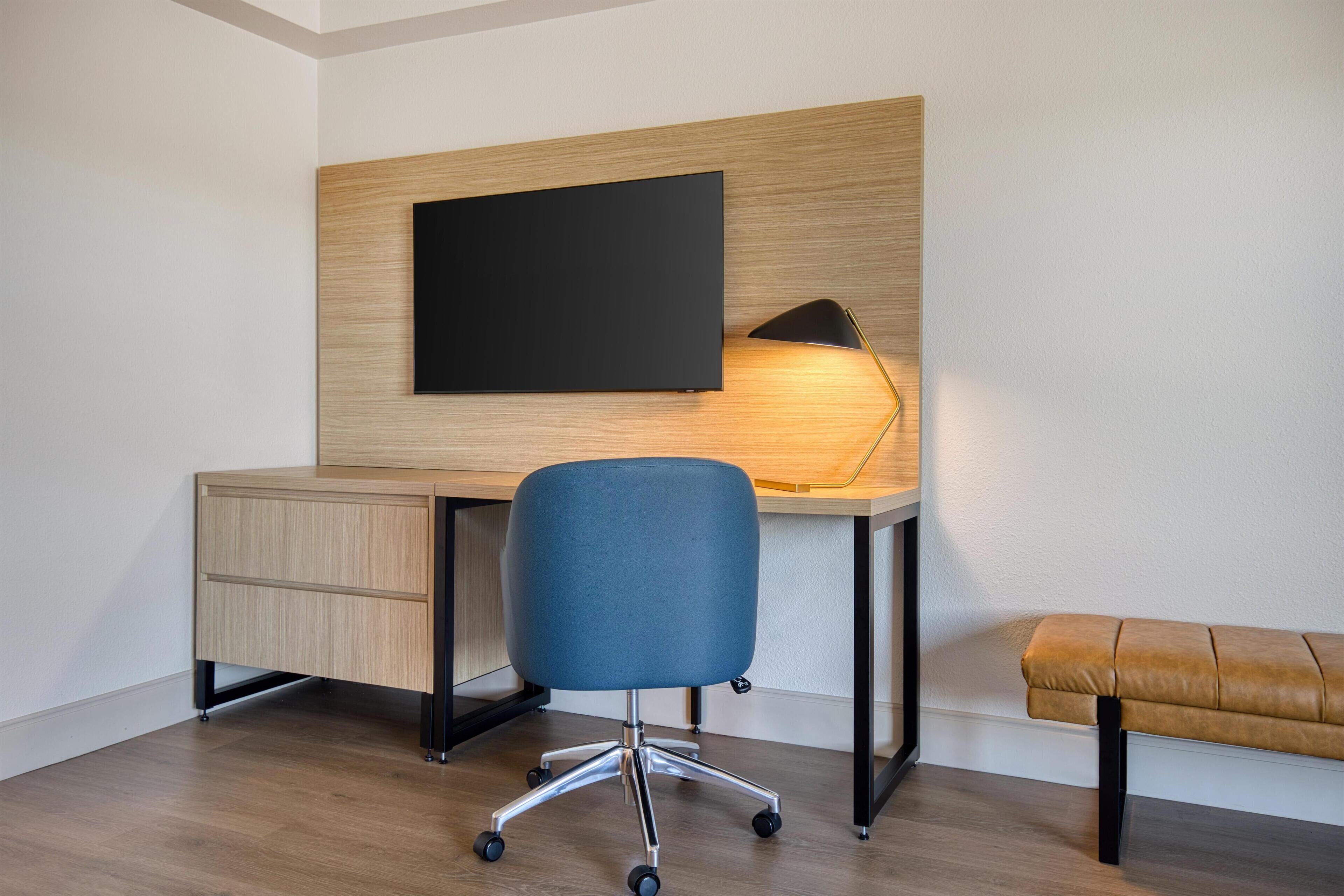 A modern office space with a desk, chair, and bench.