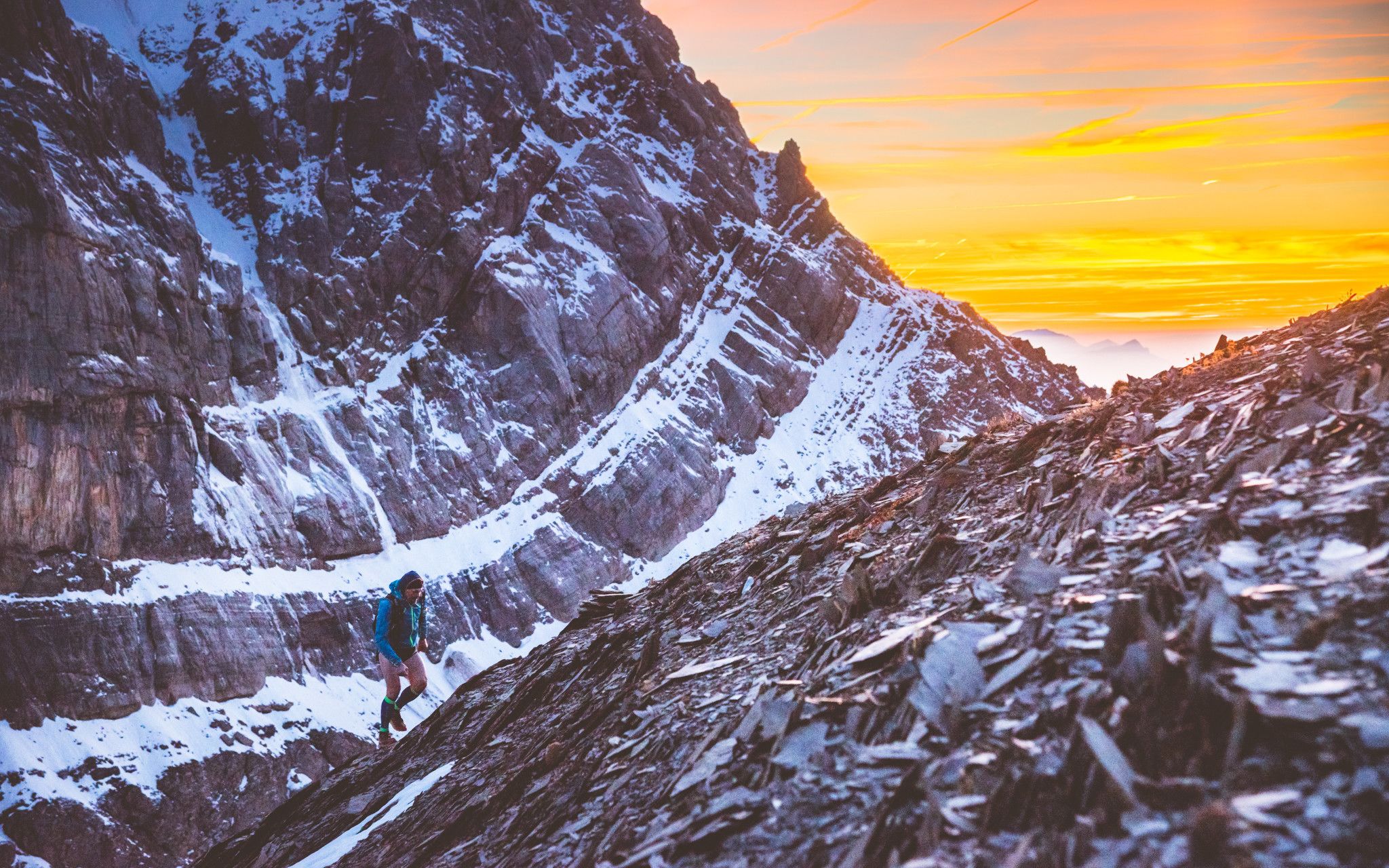 Un sendero montañoso y rocoso, estrecho, con una persona caminando.