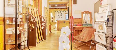 Une pièce avec un plancher en bois, une vitrine, un fauteuil en cuir marron et une orchidée blanche.