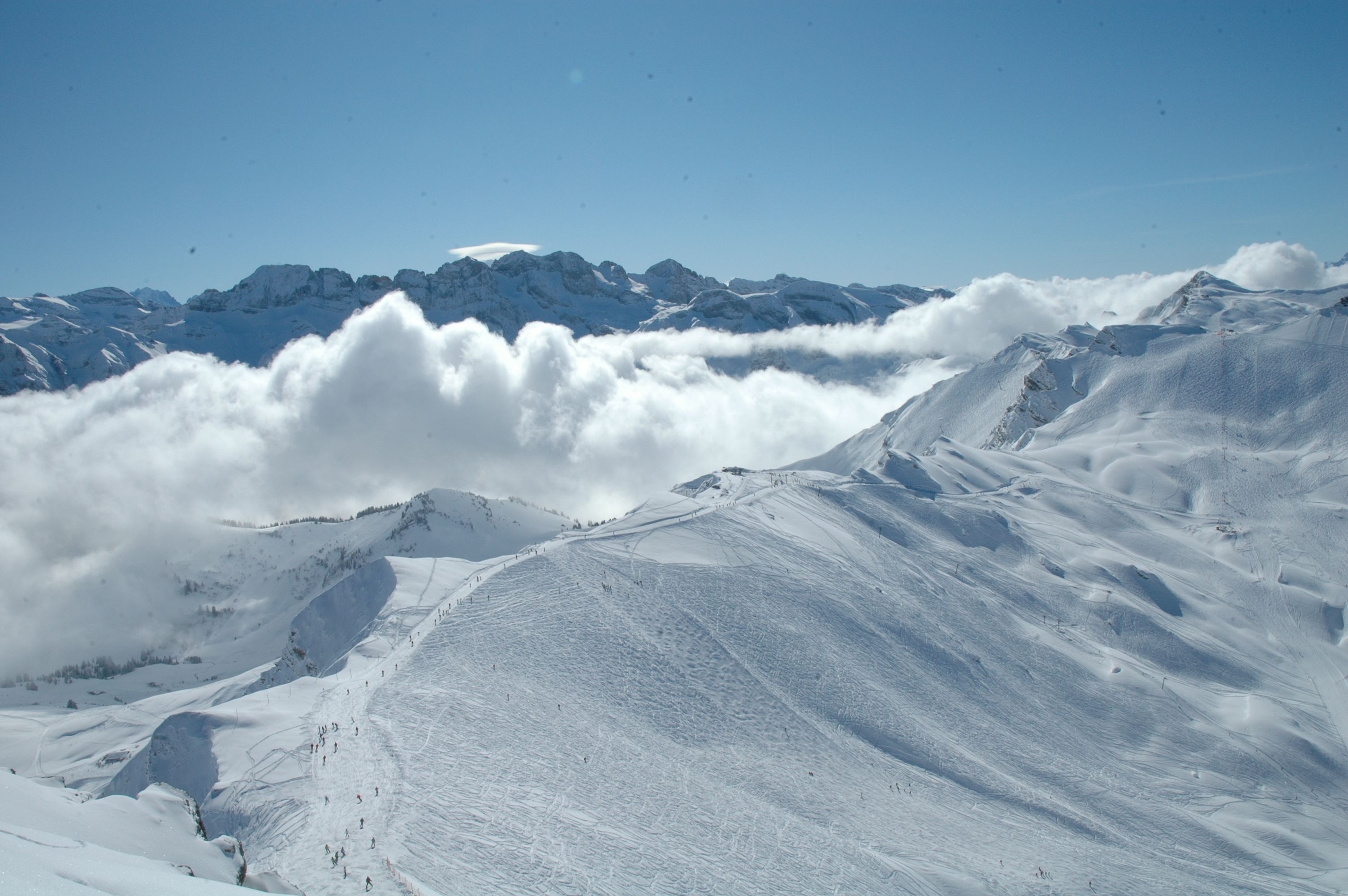 Un paysage montagneux enneigé, avec un ciel dégagé et des sommets lointains.