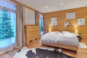 Un dormitorio con paneles de madera, una cama, dos lámparas de noche y decoración en la pared.
