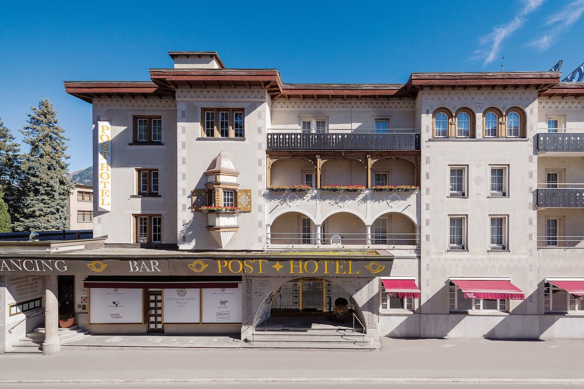 Ett hotell med en bar och en restaurang på bottenvåningen, med en traditionell arkitektonisk stil som kännetecknas av välvda fönster och balkonger.