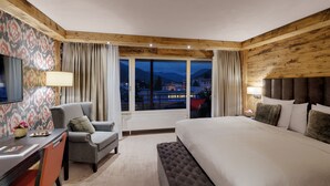 A hotel room with a bed, a desk, a chair, and a view of the mountains. - Morosani Schweizerhof (Davos)