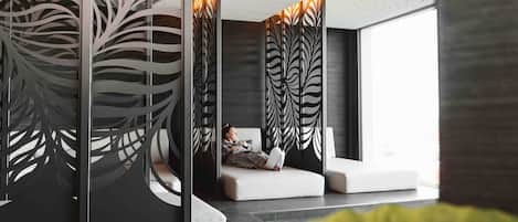 A modern interior with a seating area, decorative panels, and a view through a glass partition.