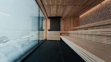A modern interior with wooden paneling, a black tiled floor, and a view of a snowy landscape through a large glass window.