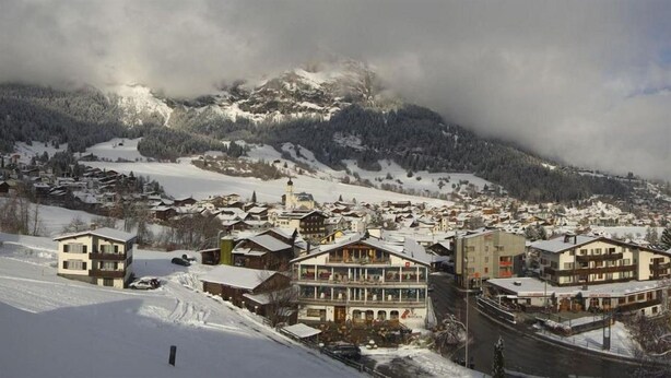 A snow-covered village with buildings and a mountain in the background. - T3 Alpenhotel Flims (Flims)