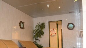 A hotel lobby with a reception desk, a seating area with benches, and a decorative water feature. - T3 Alpenhotel Flims (Flims)