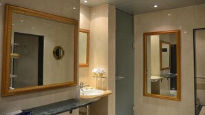 A bathroom with a large mirror, a sink, and a towel rack. - T3 Alpenhotel Flims (Flims)