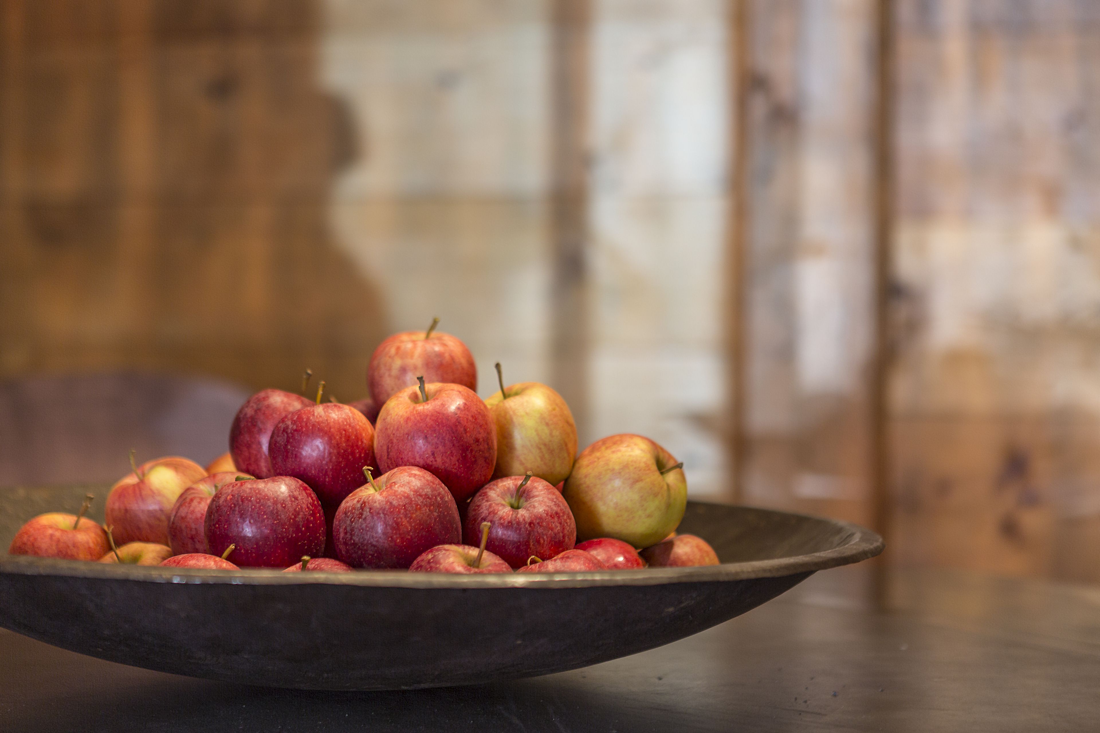 A bowl of apples on a table.