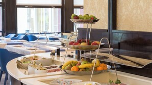 Una barra de buffet con diferentes tipos de comida y una presentación de frutas.