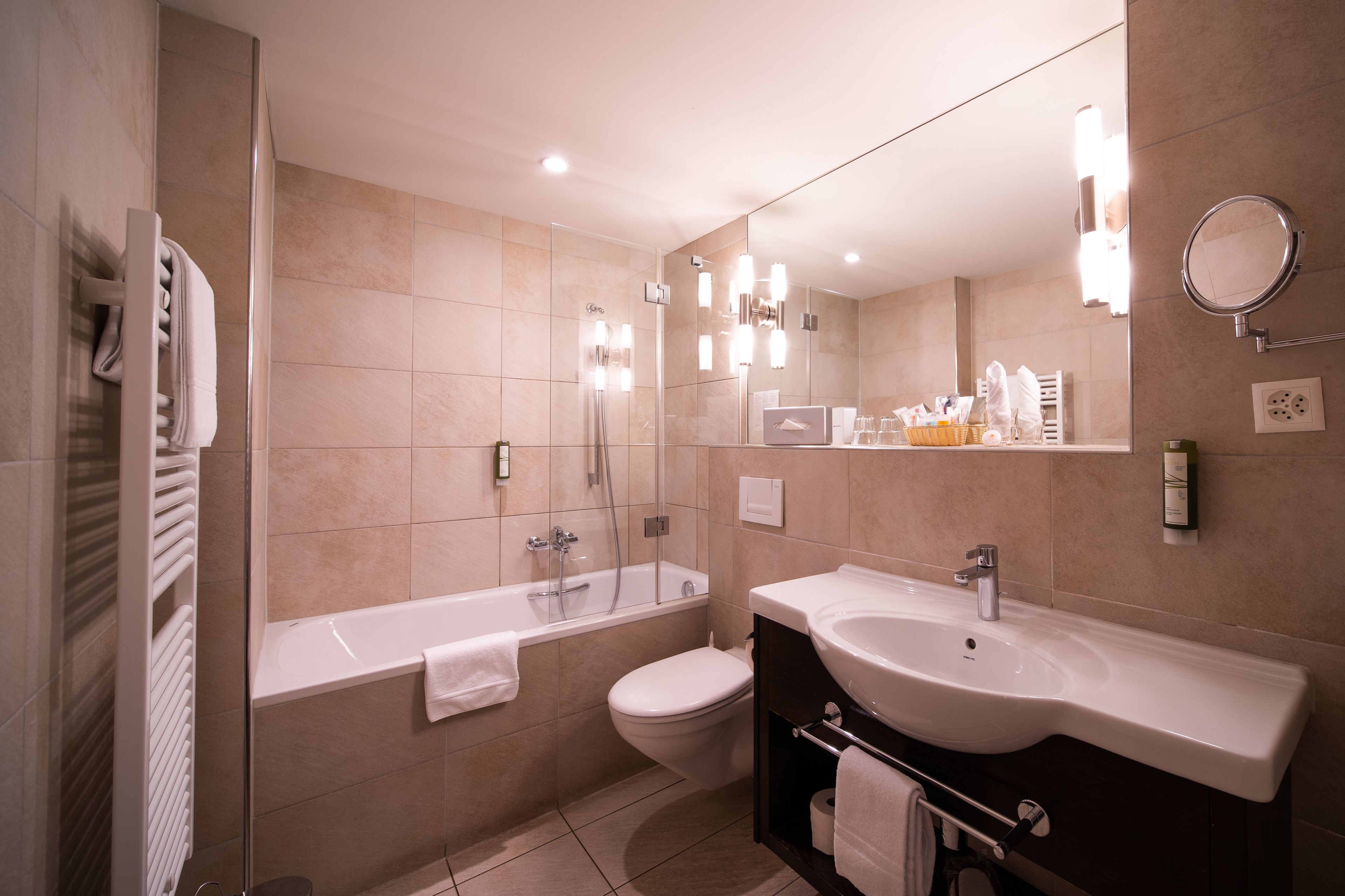 A modern bathroom with a bathtub, toilet, and vanity with a sink.
