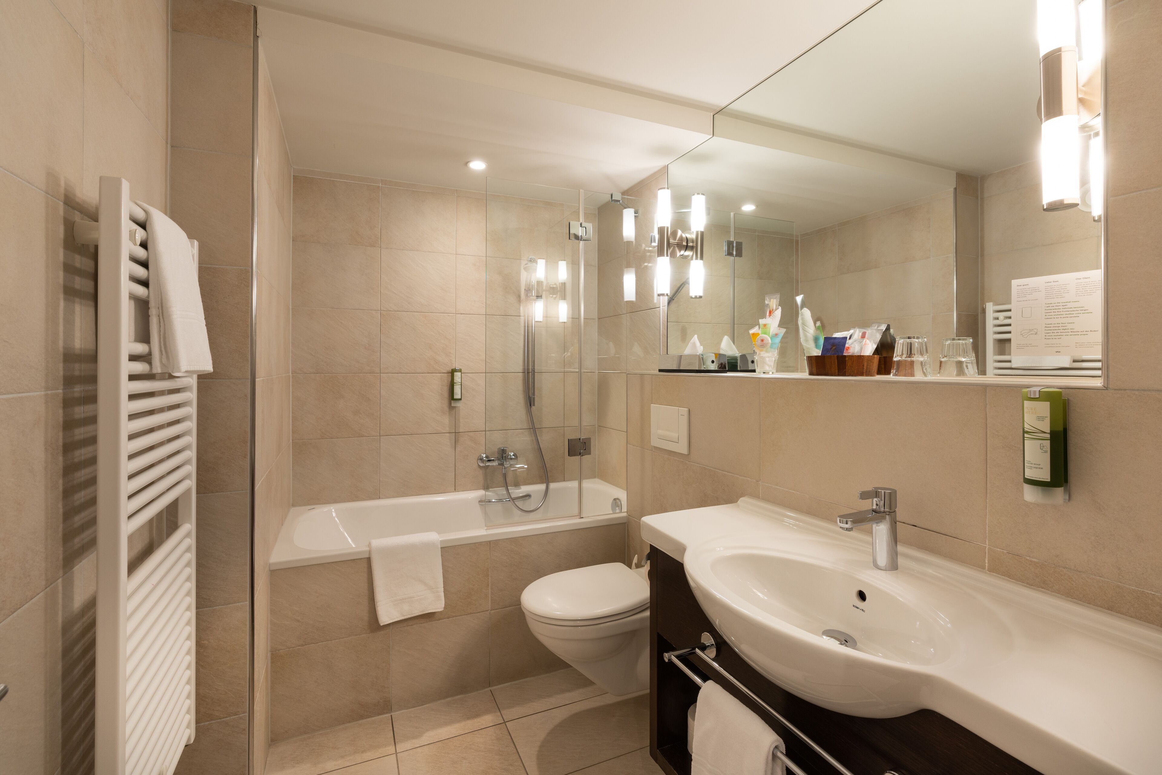 Une salle de bain moderne équipée d’une baignoire, de toilettes et d’un lavabo.