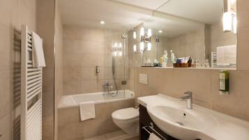 Une salle de bain moderne équipée d’une baignoire, de toilettes et d’un lavabo.
