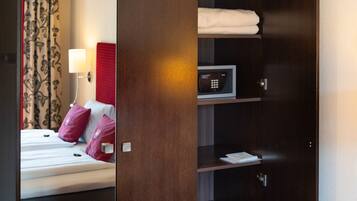 Une chambre d’hôtel avec un lit, un four à micro-ondes et une étagère sur laquelle se trouve un livre.