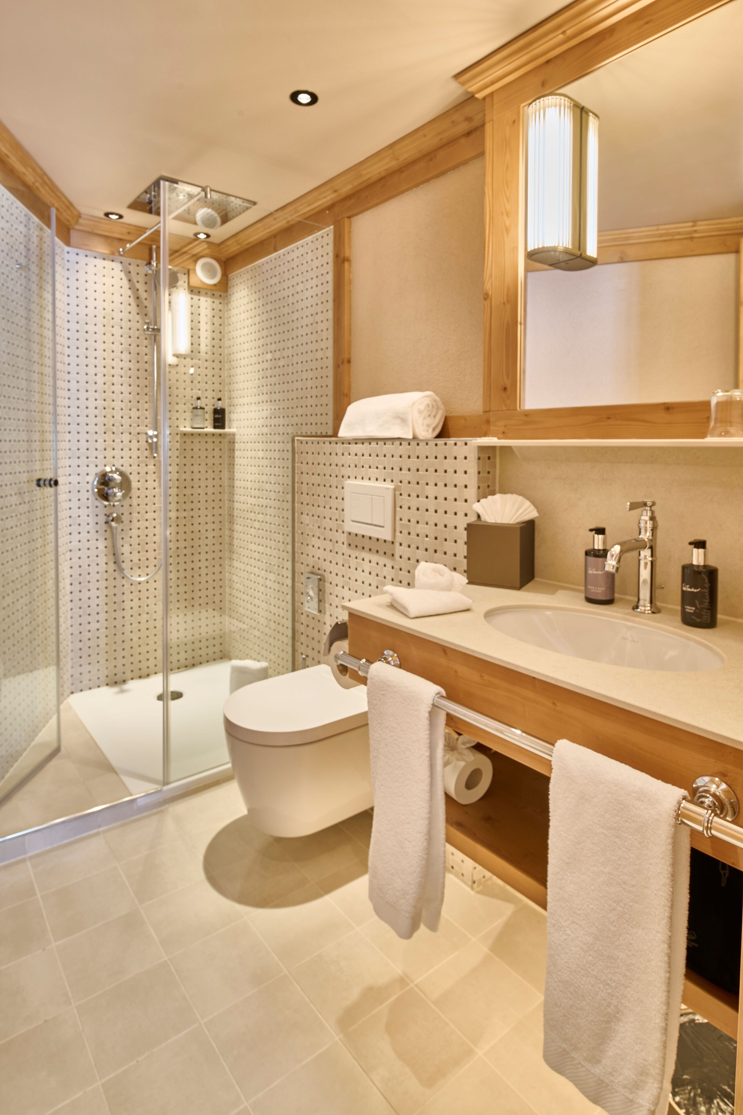 A modern bathroom with a glass-enclosed shower, a freestanding bathtub, and a vanity with a sink and mirror.