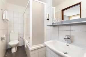 Un baño moderno con inodoro, ducha y lavamanos.