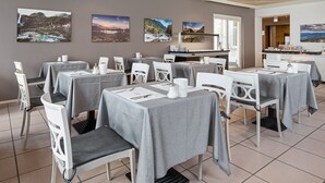 A dining area with tables set for service, white chairs, and artwork on the walls. - Hotel DU LAC Locarno (Locarno)