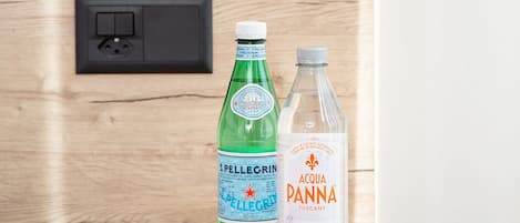 A wooden table with two bottles of water and a magazine.