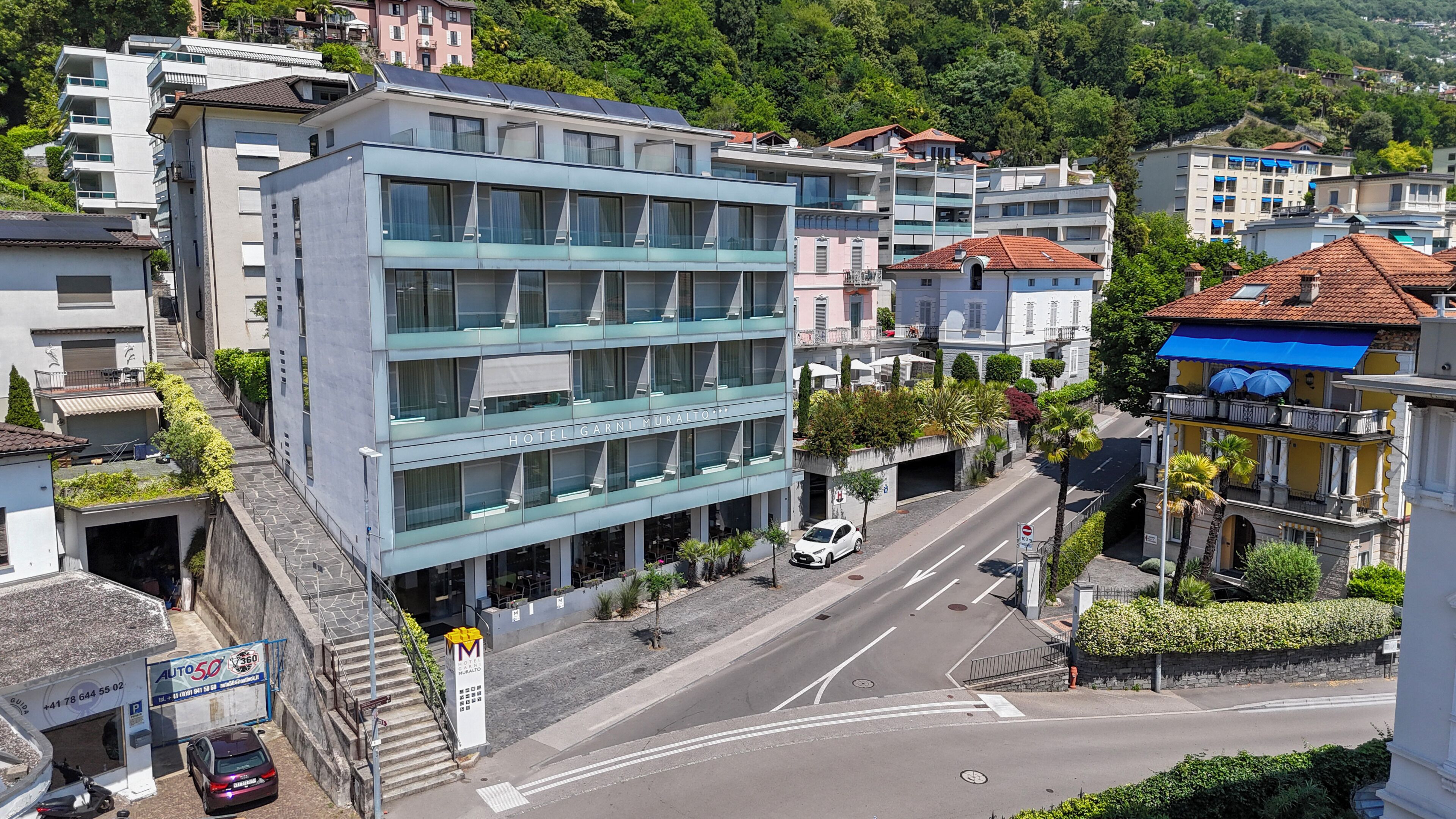 Un hôtel à plusieurs étages, doté d’une architecture moderne, d’une entrée bien visible et situé sur une rue animée.