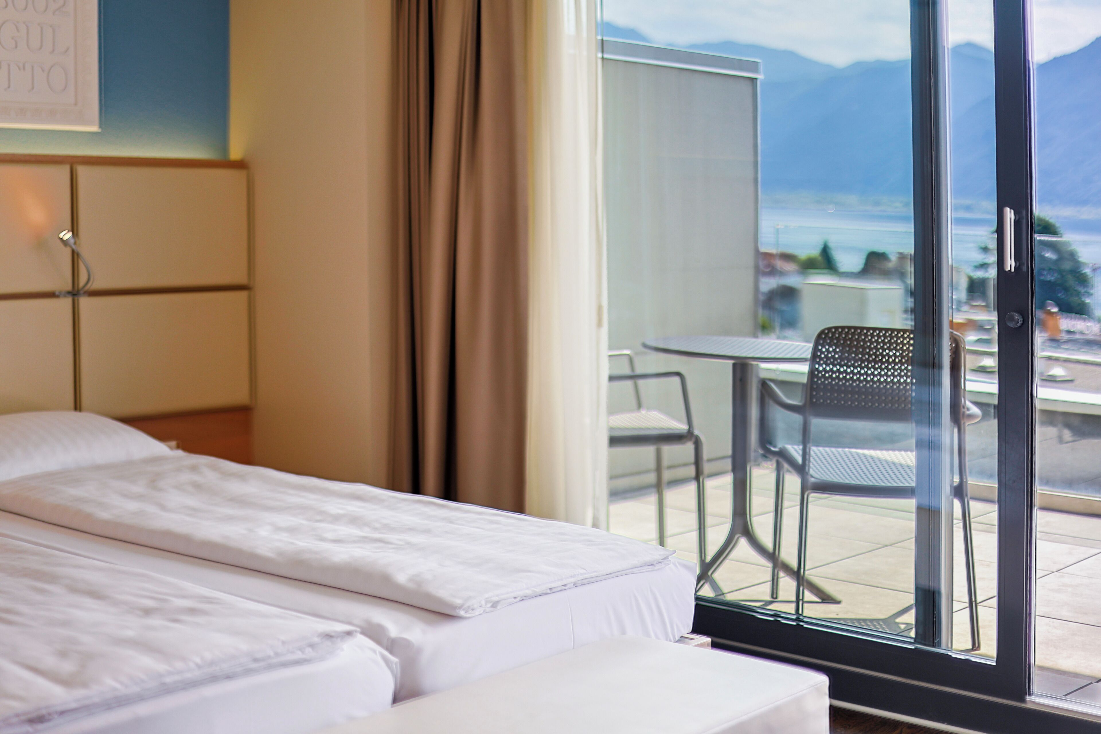 Een hotelkamer met een bed, een tafeltje en een stoel.