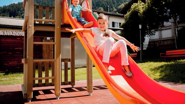 Un parque infantil con un tobogán y una estructura para escalar.