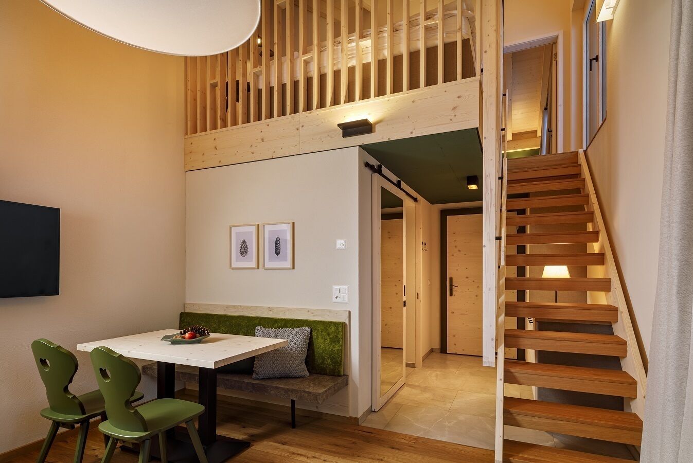 A modern interior with a wooden staircase, a dining area with a table and chairs, and a bench with cushions.