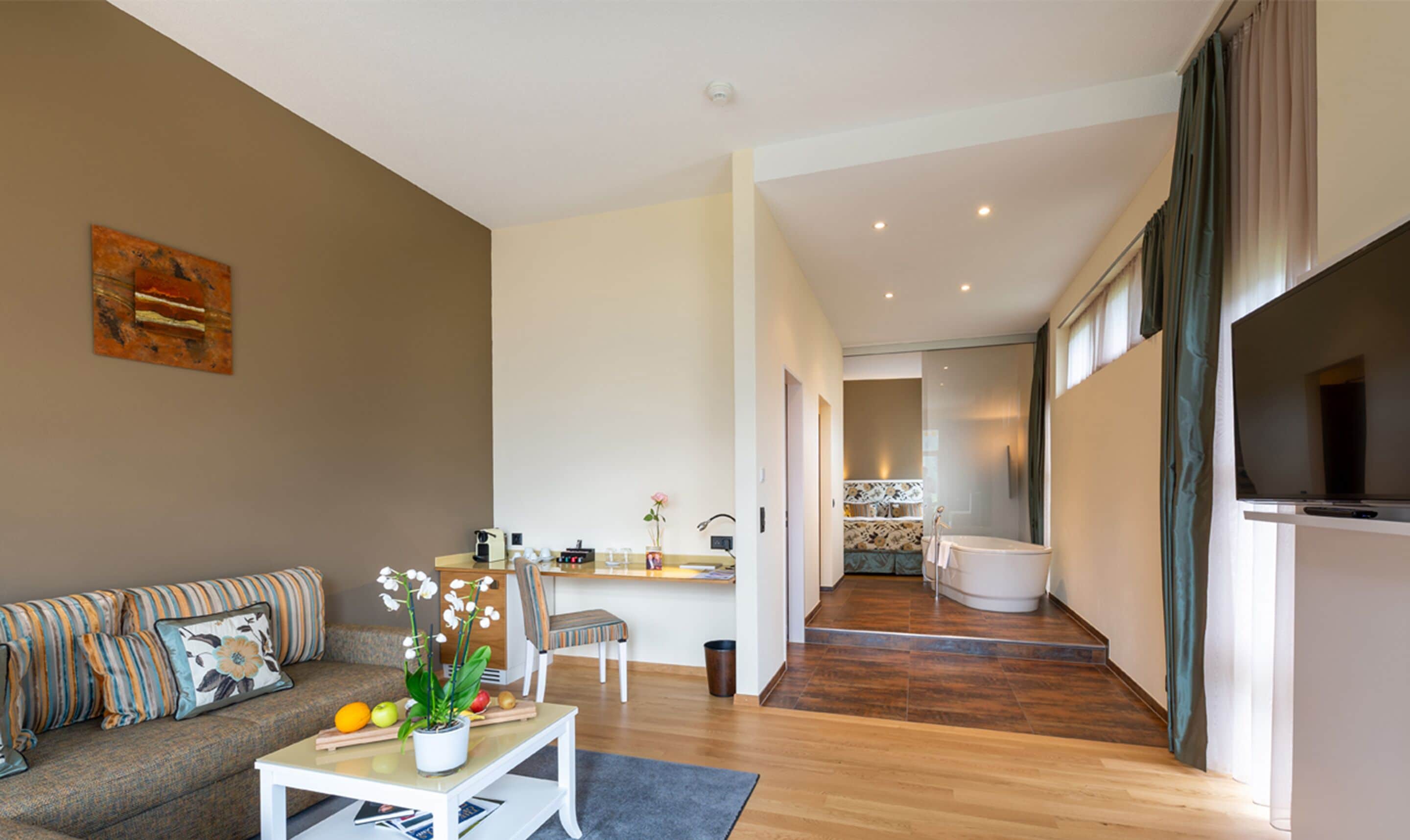 A modern living room with a sofa, coffee table, and a kitchen area in the background.