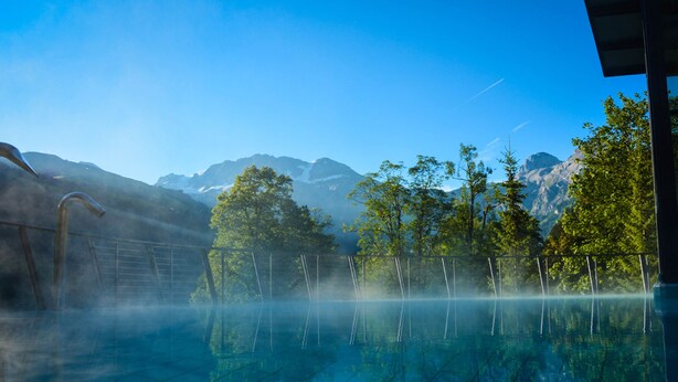 Una vista despejada de un paisaje montañoso con una piscina al frente.
