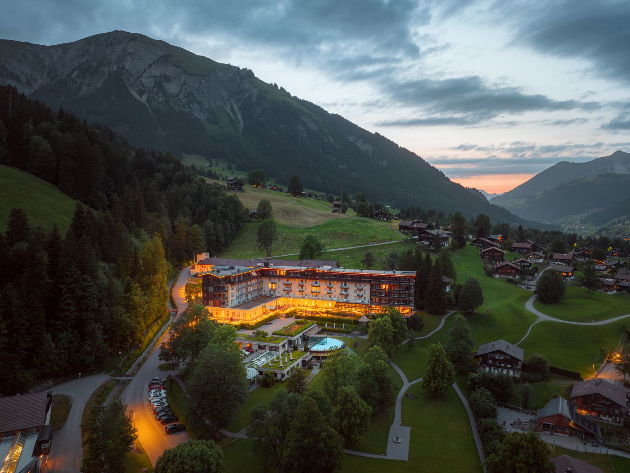 Un hotel con varias construcciones, rodeado de exuberante vegetación y montañas.