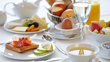 A breakfast setting with various foods and drinks, including toast, fruit, eggs, and a glass of juice.