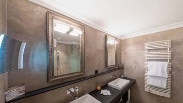 Une salle de bain avec deux lavabos, un grand miroir et un porte-serviettes.