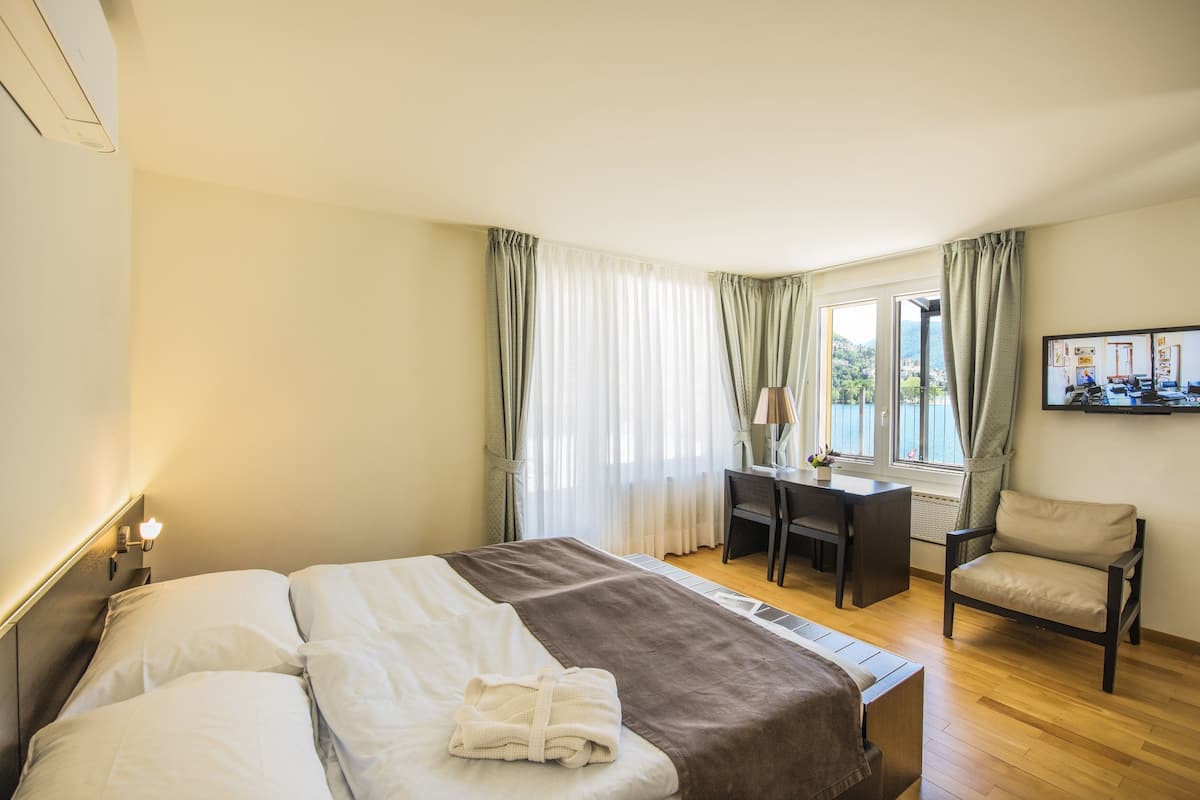 A hotel room with a bed, a desk, and a chair.