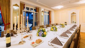 A formal dining room with a long table set for a meal, candles, and floral centerpieces. - Des Alpes Luzern (Lucerne)