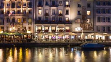Un hotel histórico con varios pisos, zonas de estar al aire libre y vistas al río.