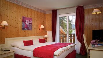 Habitación de hotel con una cama grande, dos lámparas de noche, un escritorio con silla, una ventana con cortinas y un cuadro en la pared.