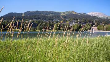 Blick auf einen See mit Häusern und einem Berg im Hintergrund.