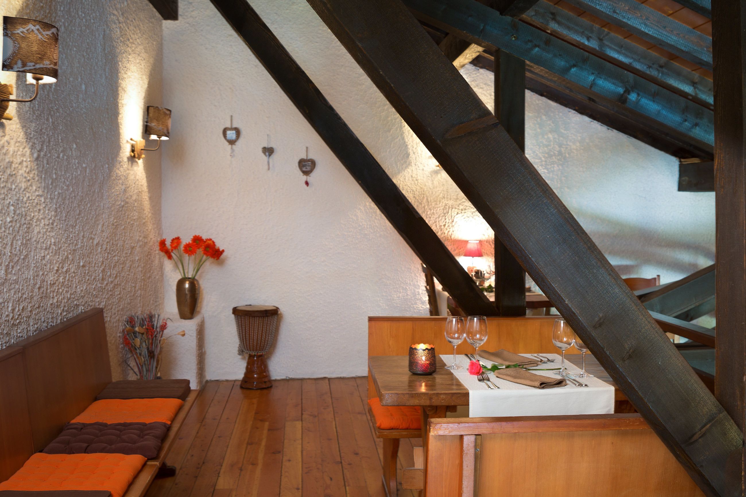 Un comedor acogedor con muebles de madera, un mantel blanco y una vela sobre la mesa.