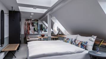 A modern bedroom with a skylight, a bed, a desk, and a wardrobe.