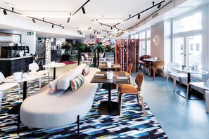 A modern cafe with a central seating area, tables, and a bar. - Sorell Boutique-Hotel City Weissenstein St. Gallen (St. Gallen)