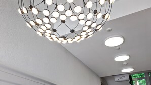 A modern staircase with a geometric chandelier and recessed lighting. -  Sorell Boutique-Hotel City Weissenstein St. Gallen (St. Gallen)