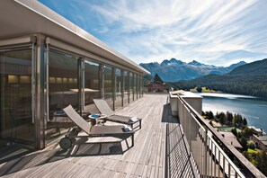 A balcony with sun loungers and a view of a lake and mountains. - Schweizerhof Swiss Quality Hotel (St. Moritz)