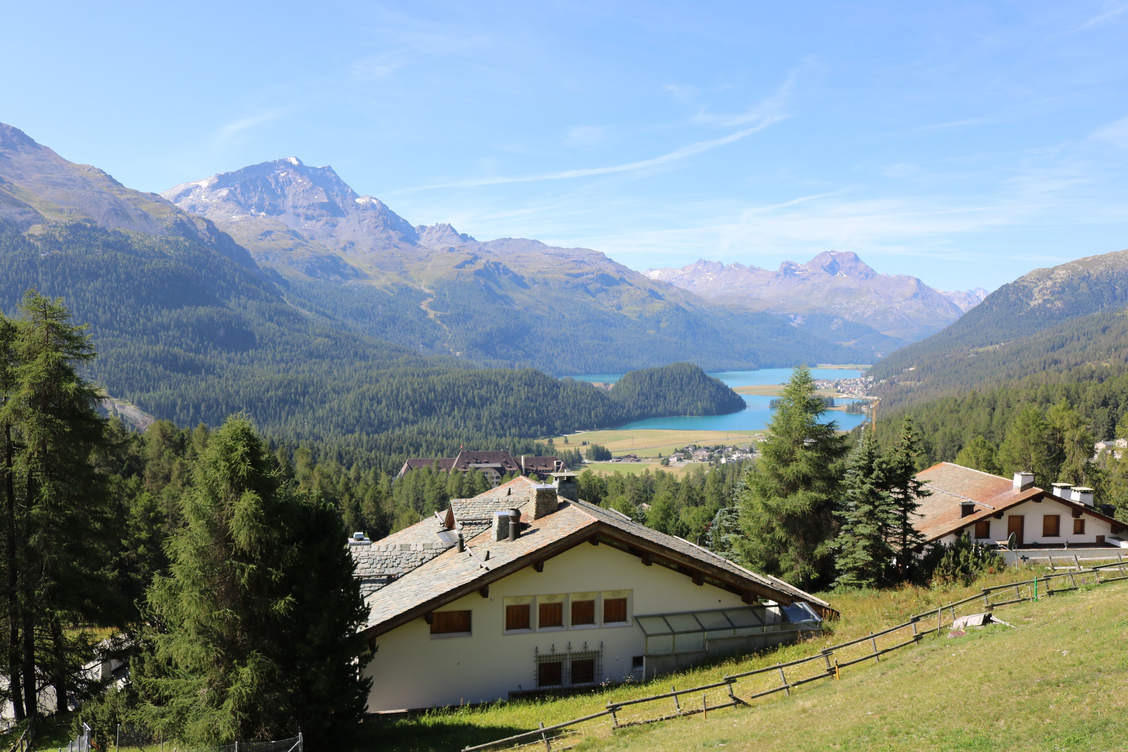 A mountain house with a view of a lake and mountains.