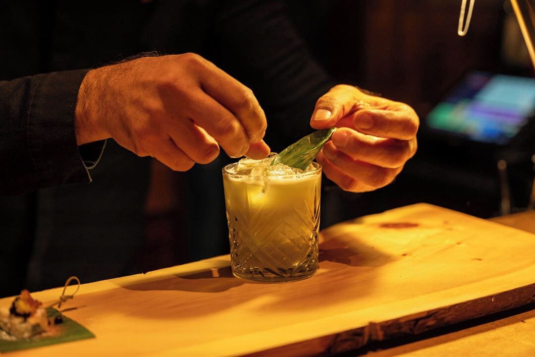 A person stirring a drink in a textured glass.