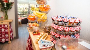 A buffet table with various food items, including fruits, pastries, and jars of spreads. - Hotel Bristol (Bagnes)