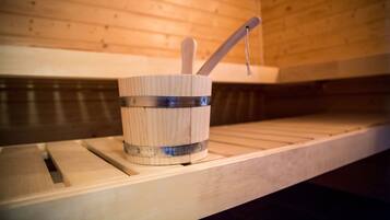 A wooden sauna with a wooden bucket and a wooden ladle on a shelf.