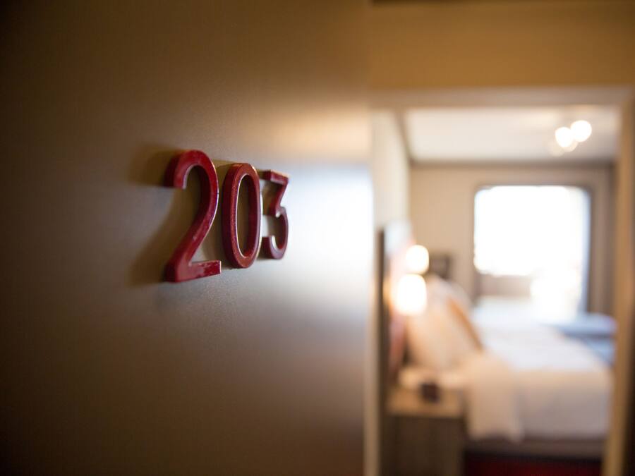 Hotelkamer nummer 203 met een bed en nachtkastje op de achtergrond.